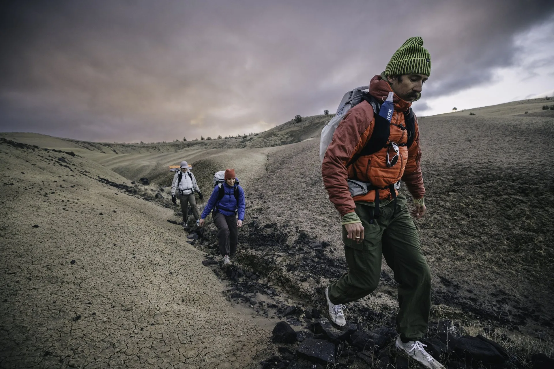 Active Insulation - hikers moving across hillside terrain at dusk.